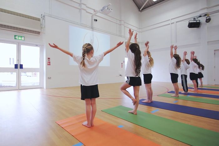 Pupils following a yoga class at school